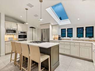 This stunning kitchen boasts a spacious island with seating, perfect for casual dining and entertaining.