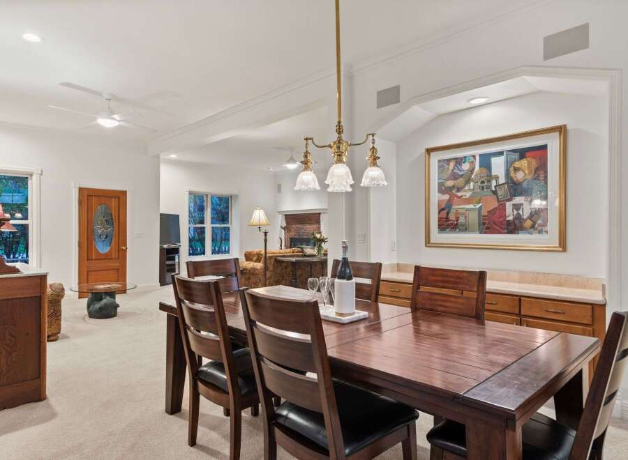 This stunning dining room boasts a large, dark wood table perfect for family gatherings, complemented by comfortable leather chairs.