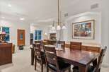 This stunning dining room boasts a large, dark wood table perfect for family gatherings, complemented by comfortable leather chairs.