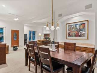This stunning dining room boasts a large, dark wood table perfect for family gatherings, complemented by comfortable leather chairs.