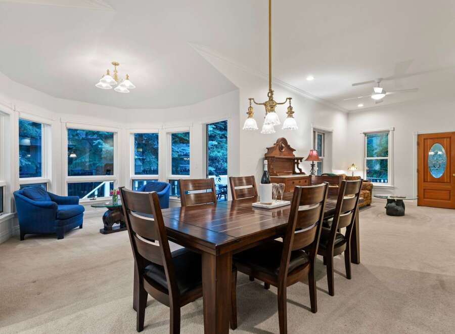 This stunning home boasts a spacious dining area with a large wooden table, perfect for family gatherings.