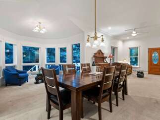 This stunning home boasts a spacious dining area with a large wooden table, perfect for family gatherings.