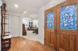 This stunning home features hardwood floors, an antique hall tree, and a beautiful stained-glass double door entryway.