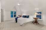 This bedroom boasts a serene atmosphere with its vaulted ceiling and plush carpeting.