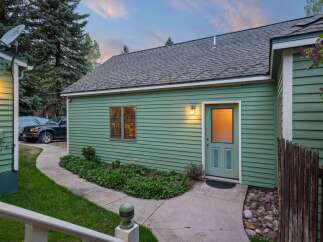 Charming green guest house with private entrance and walkway.
