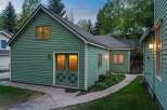 Charming green house with a spacious backyard and well-maintained landscaping.
