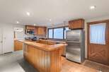 This charming kitchen boasts a unique wooden breakfast bar, perfect for casual dining.