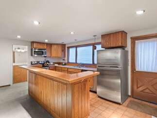 This charming kitchen boasts a unique wooden breakfast bar, perfect for casual dining.
