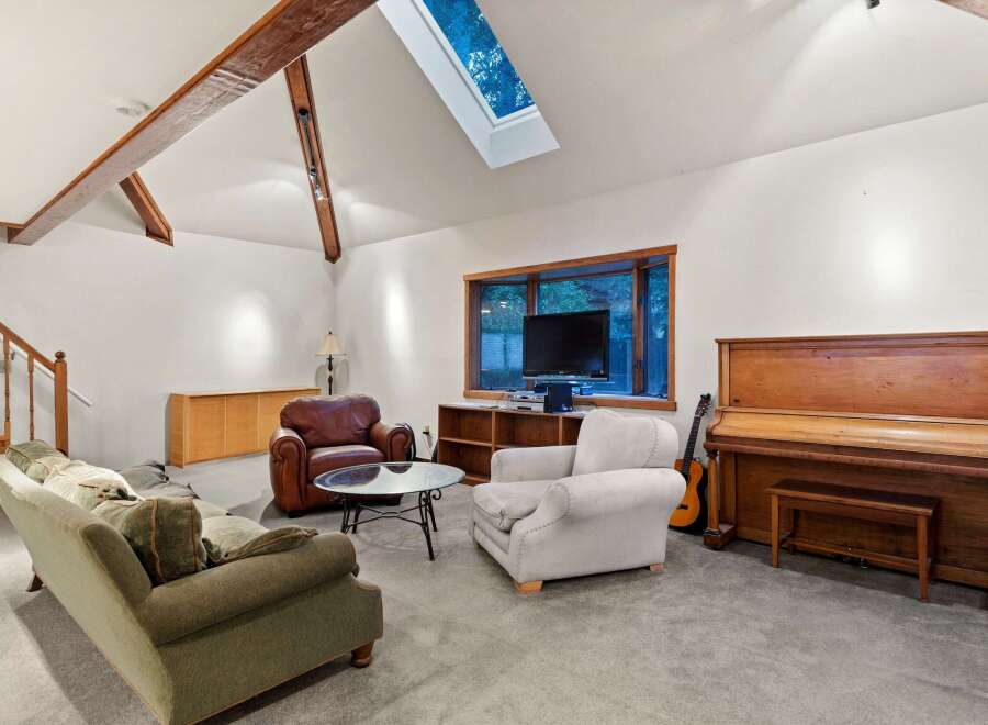 Spacious living room with vaulted ceilings and skylights, creating an open and airy atmosphere.