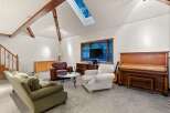 Spacious living room with vaulted ceilings and skylights, creating an open and airy atmosphere.