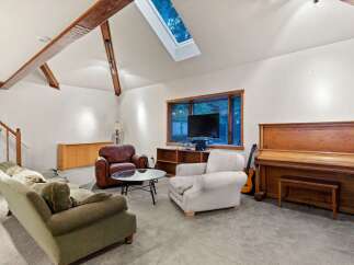 Spacious living room with vaulted ceilings and skylights, creating an open and airy atmosphere.