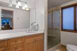 This stunning bathroom boasts a spacious vanity with ample storage, complemented by a sleek, frameless glass shower enclosure.
