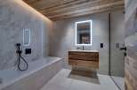 Luxurious bathroom with marble walls and wooden accents.