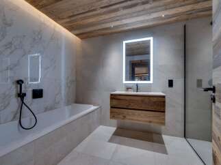 Luxurious bathroom with marble walls and wooden accents.