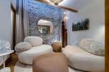 Relax in style in this luxurious living room, featuring a stunning stone wall, plush seating, and modern decor.