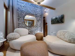 Relax in style in this luxurious living room, featuring a stunning stone wall, plush seating, and modern decor.
