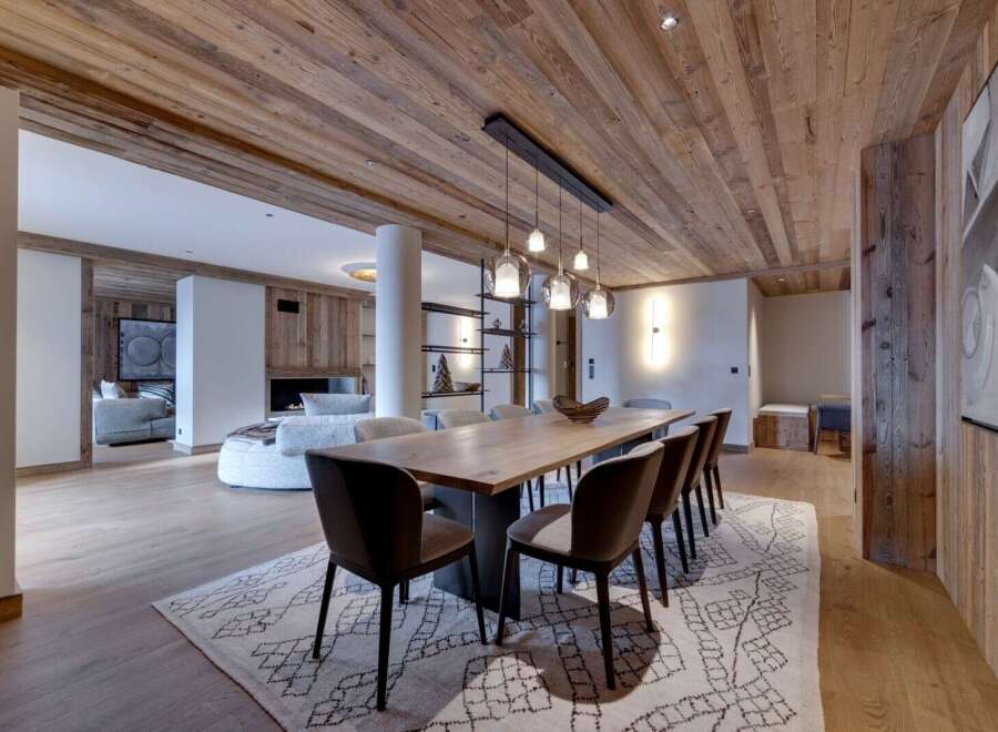 This stunning chalet boasts a spacious open-plan living area with a large dining table perfect for entertaining.