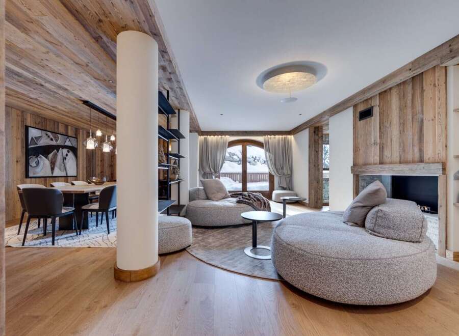 This stunning chalet boasts a spacious open-plan living area with floor-to-ceiling windows offering breathtaking mountain views.