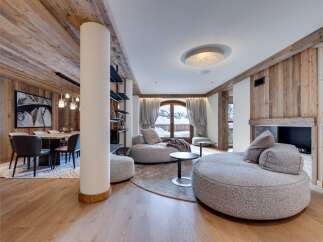 This stunning chalet boasts a spacious open-plan living area with floor-to-ceiling windows offering breathtaking mountain views.