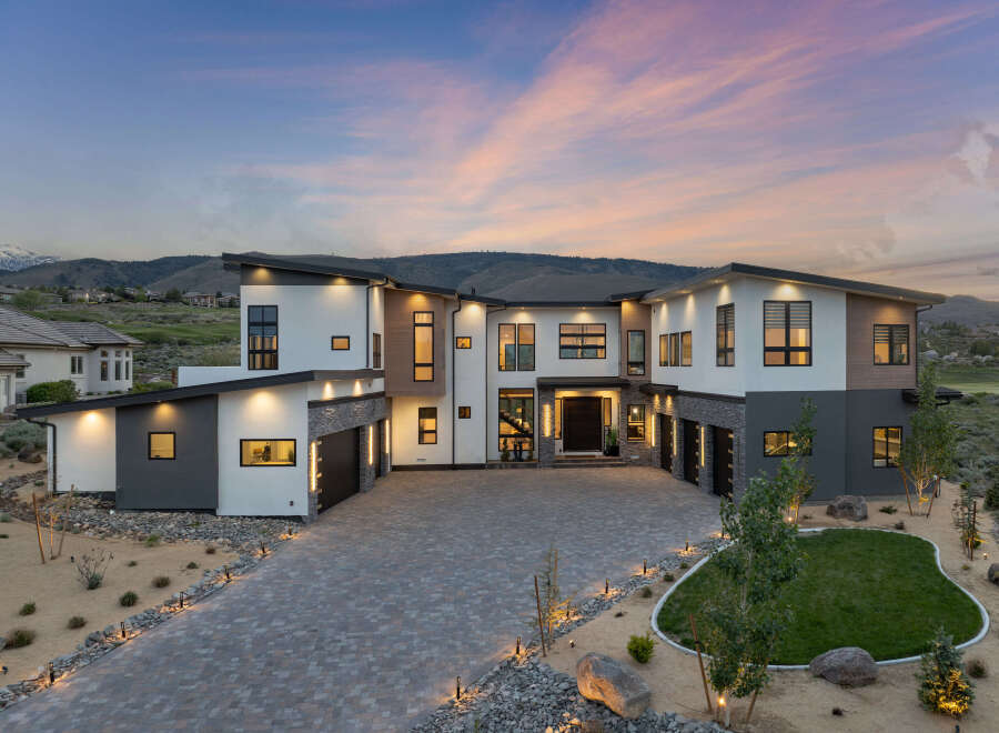 Stunning modern home nestled in the hills, boasting a spacious driveway and beautifully landscaped yard.