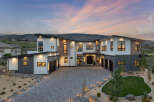Stunning modern home nestled in the hills, boasting a spacious driveway and beautifully landscaped yard.