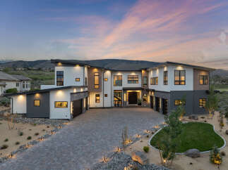 Stunning modern home nestled in the hills, boasting a spacious driveway and beautifully landscaped yard.
