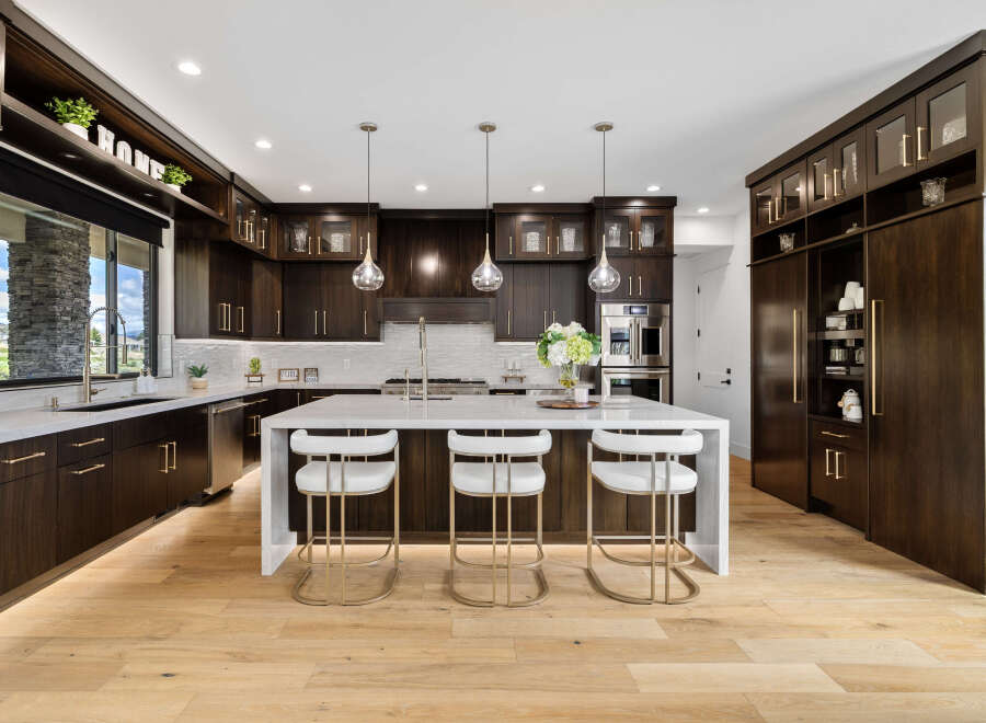 This stunning kitchen boasts a modern design with dark wood cabinetry, sleek countertops, and high-end appliances.