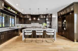 This stunning kitchen boasts a modern design with dark wood cabinetry, sleek countertops, and high-end appliances.