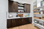 This stunning kitchen boasts a built-in pantry with ample shelving and stylish woven baskets for optimal organization.