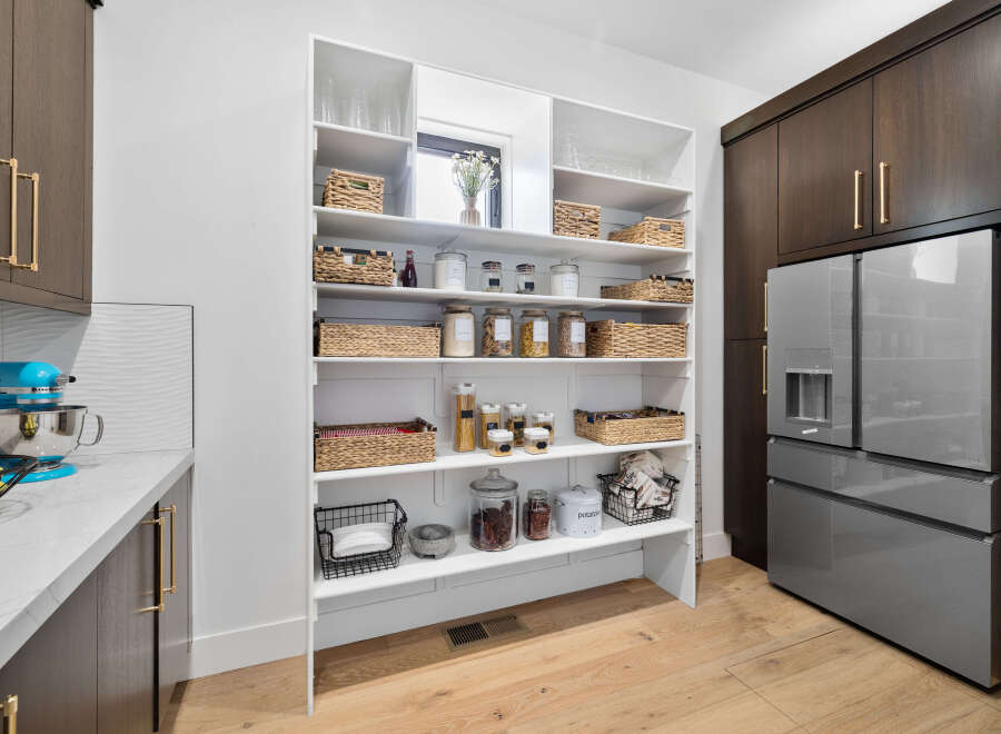 This stunning kitchen boasts a spacious pantry with ample shelving for all your storage needs.