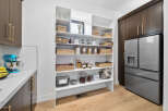 This stunning kitchen boasts a spacious pantry with ample shelving for all your storage needs.