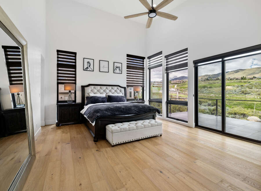 Luxurious bedroom with stunning mountain views and hardwood floors.