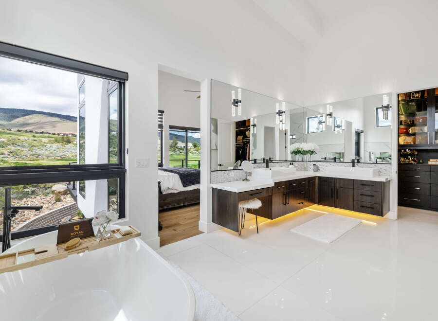 Luxurious master bathroom boasts a stunning view, double vanity with ample storage, and a freestanding soaking tub.
