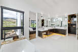 Luxurious master bathroom boasts a stunning view, double vanity with ample storage, and a freestanding soaking tub.