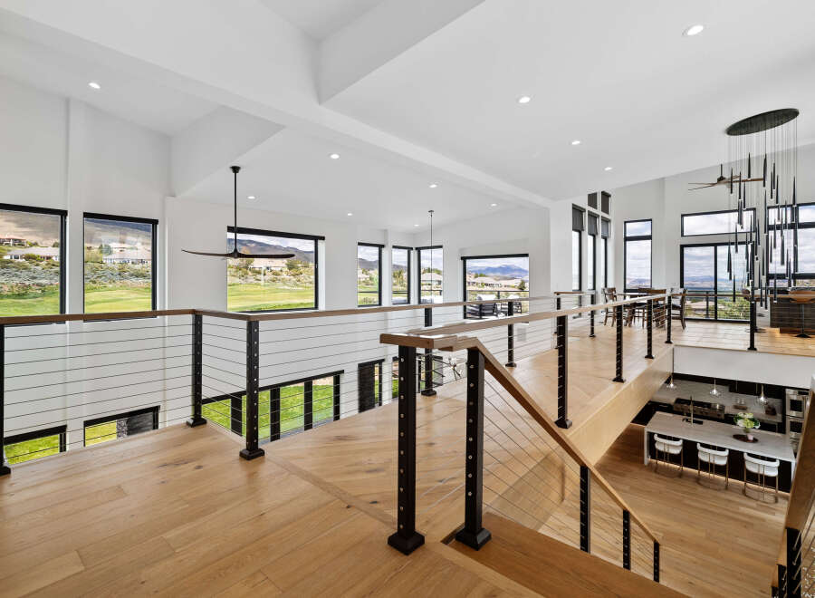 This stunning home boasts a spacious open-concept design with breathtaking views, highlighted by a modern wooden staircase and sleek metal railings.