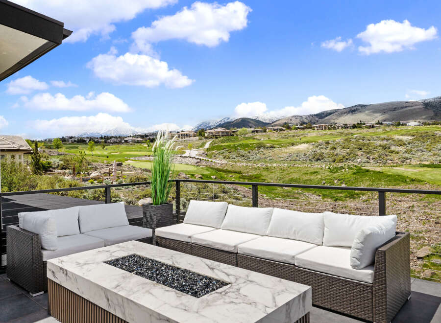 Luxury patio overlooking a stunning golf course and mountain vista.