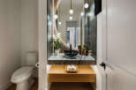 This stunning powder room boasts a modern design with a sleek black sink and marble countertop.