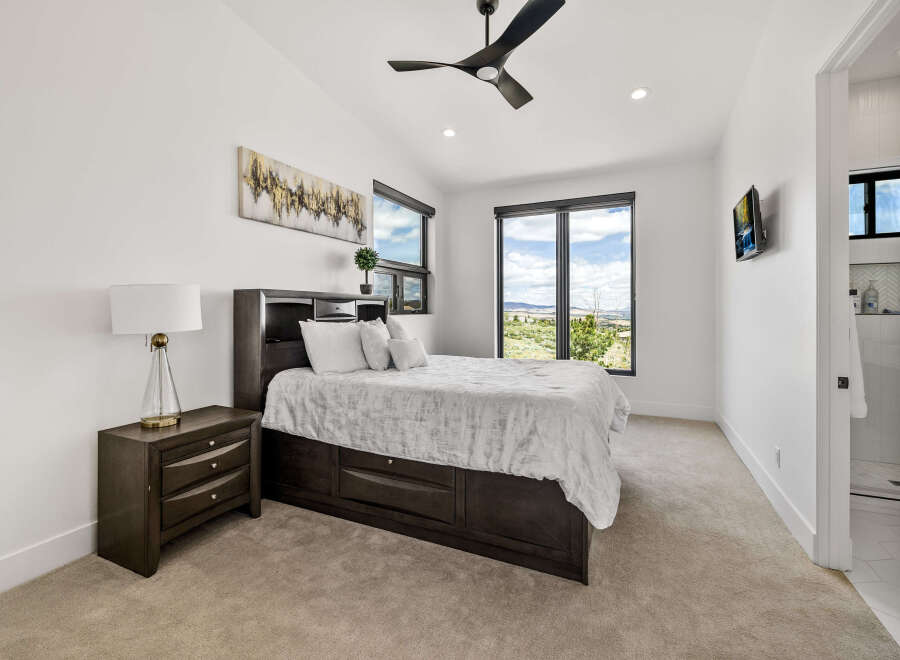 This bedroom boasts a serene atmosphere with its neutral color palette and plush carpeting.