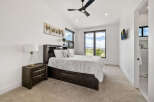 This bedroom boasts a serene atmosphere with its neutral color palette and plush carpeting.