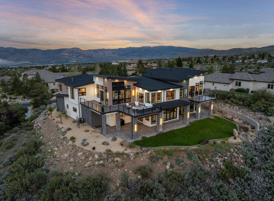 Stunning modern home nestled on a hillside, boasting panoramic mountain views.