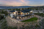 Stunning modern home nestled on a hillside, boasting panoramic mountain views.