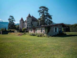 This picturesque property boasts a charming stone cottage nestled beside a majestic castle, offering breathtaking mountain views.