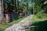 Discover this serene property featuring a picturesque pathway lined with neatly stacked firewood under charming red shelters.