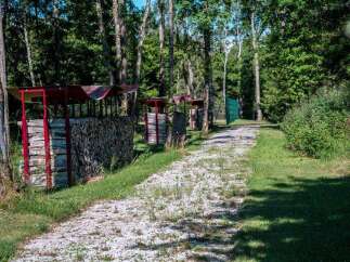 Discover this serene property featuring a picturesque pathway lined with neatly stacked firewood under charming red shelters.