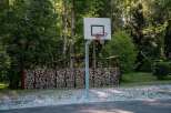 Outdoor basketball court nestled in a wooded area, providing a unique and serene playing experience.