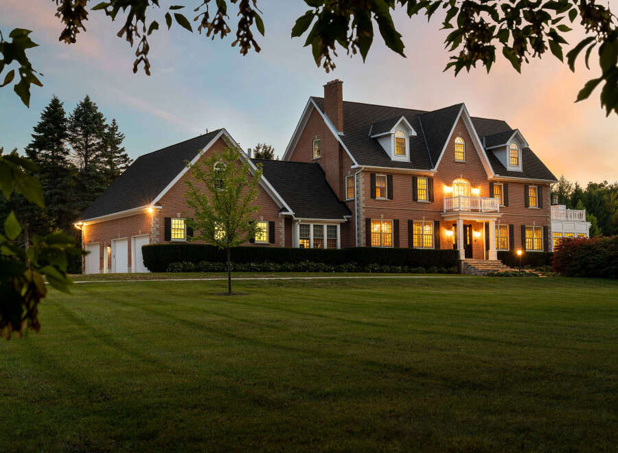This stunning brick home boasts a spacious layout, complete with a three-car garage and beautifully landscaped grounds.