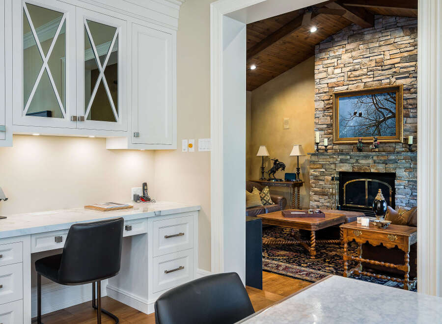 This stunning home boasts a bright and airy kitchen with custom cabinetry and a built-in workspace, perfect for busy professionals.