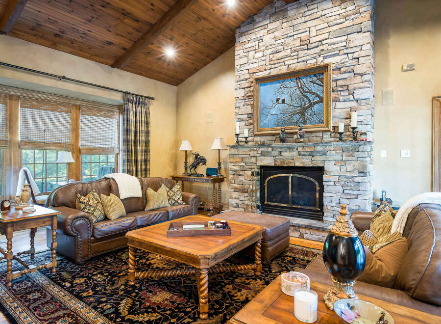 This stunning living room boasts a cozy stone fireplace, perfect for relaxing evenings.