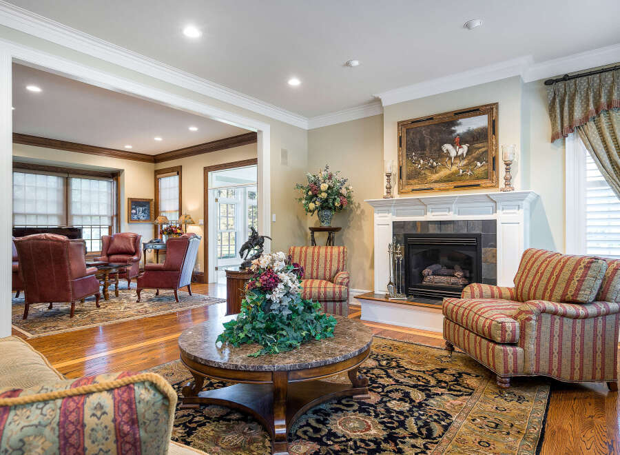 This stunning living room boasts hardwood floors, a cozy fireplace, and elegant furnishings.