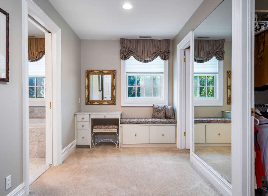 This luxurious master suite boasts a spacious walk-in closet with ample storage and built-in shelving.